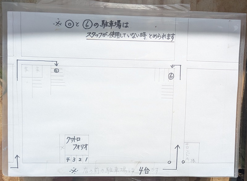 クワトロフォリオの店舗に掲示された店舗前4台と条件付き2台の駐車場案内